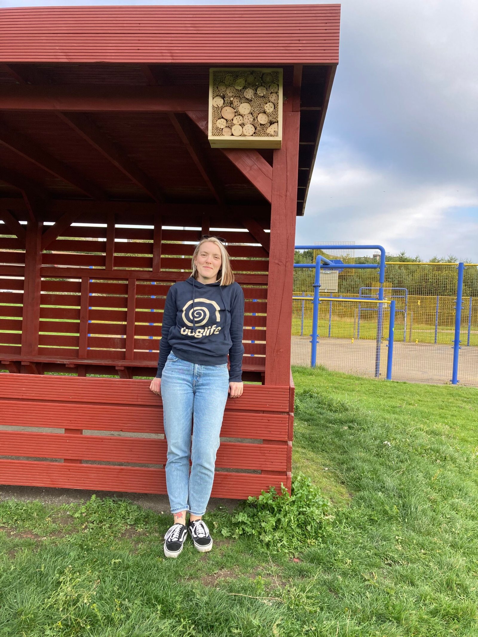 Ruth Quigley standing below the completed Bee hotel mounted to the top of the classroom.